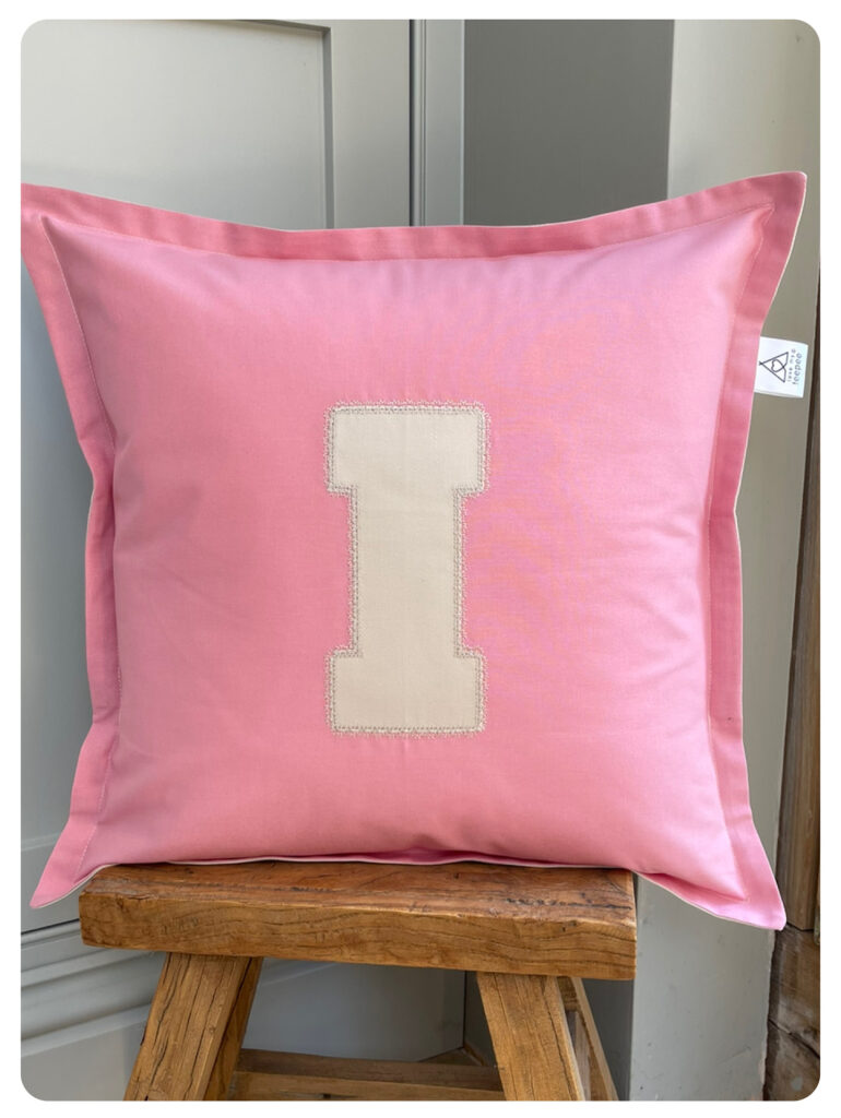 Personalised kids cushion in pink cotton fabric with cream lace-stitched initial I, handmade keepsake scatter cushion for nurseries, bedrooms, or playrooms